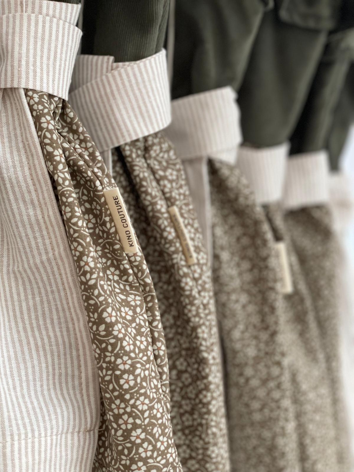 Taillendetail von Dirndl Grete mit gestreifter Schürze und geblümtem Baumwollrock