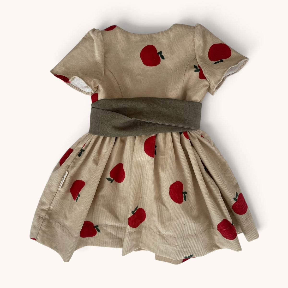 Rückansicht von Dirndl Polly mit rotem Apfelmuster und graugrünem Schürzenband