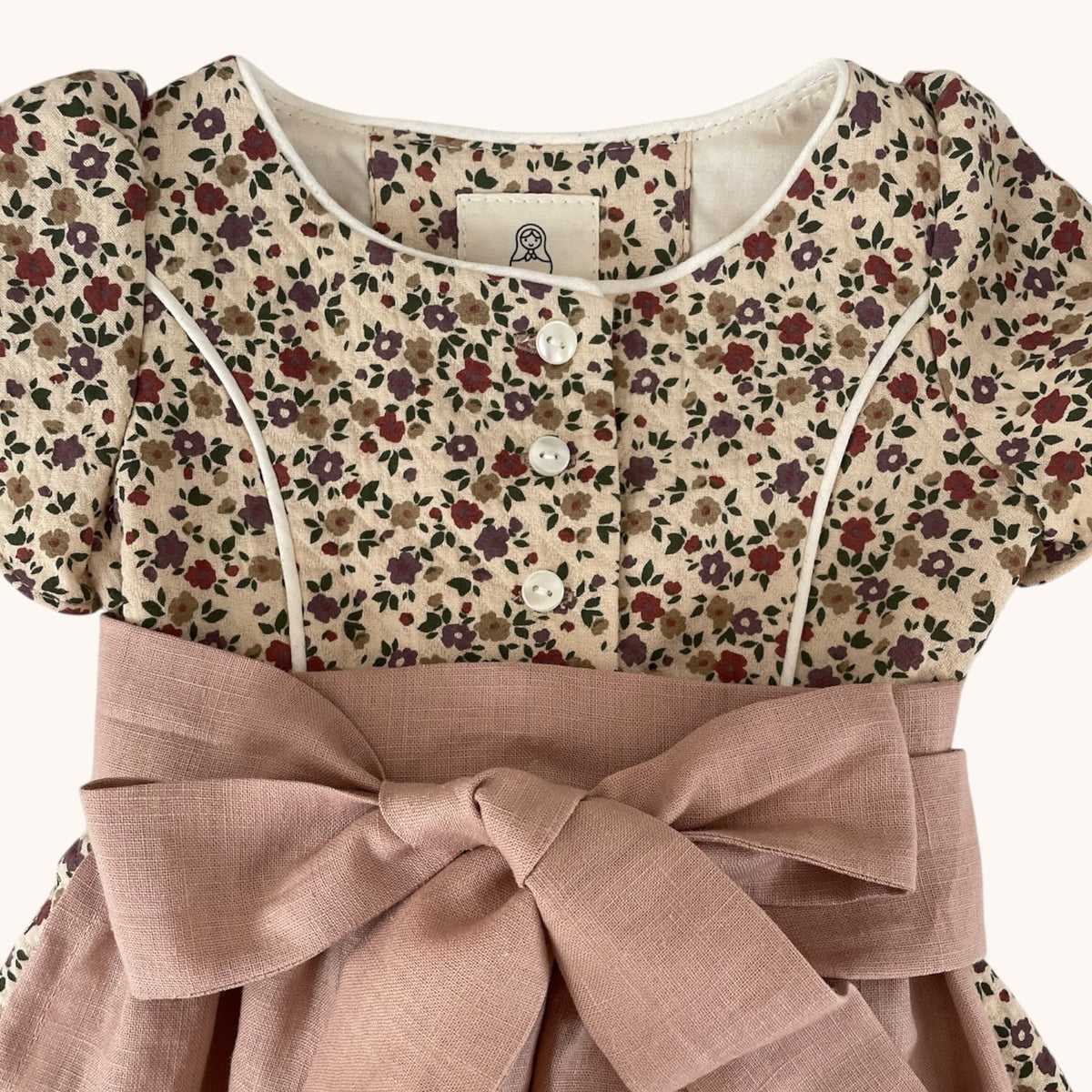 Detail des floral gemusterten Oberteils und der gebundenen Schürze von Dirndl Marie